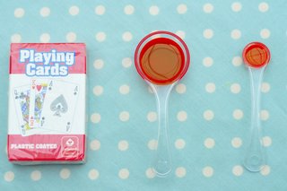 A spoonful of olive oil next to a pack of cards