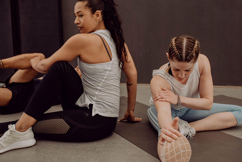 Two young women doing a workout and stretching
