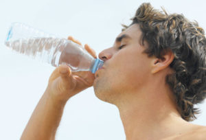 Человек пьёт минеральную воду